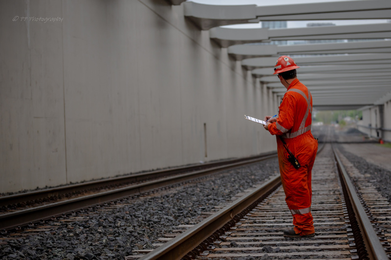 A TTR Employee with a clipboard looking away from the viewer into the distance