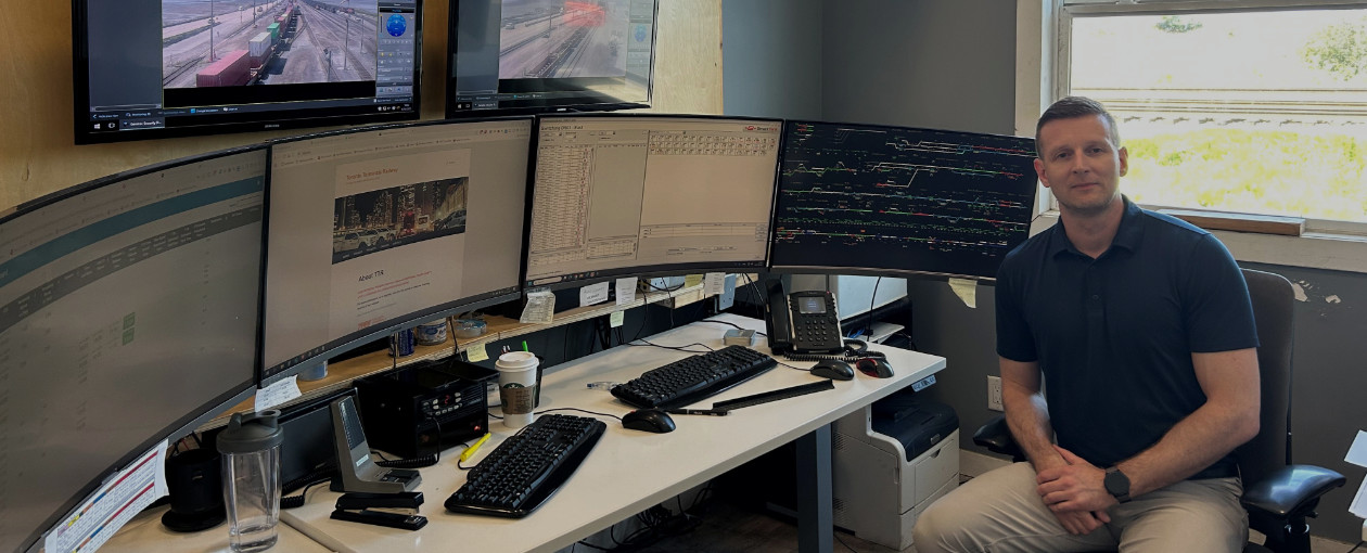An Image showing a TTR employee sitting at a desk in an office with 4 computer screens in the TTR West Location in BC