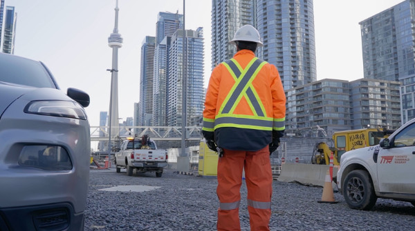 TTR Employee looking at the CN Tower surrounded by TTR trucks