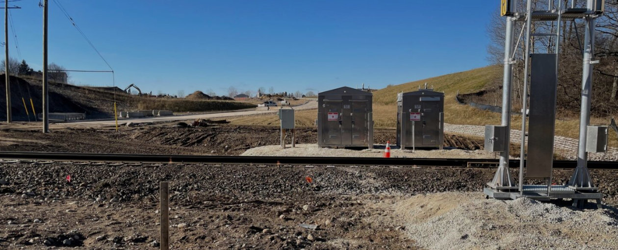 Image of tracks and metal compartments at a crossing
