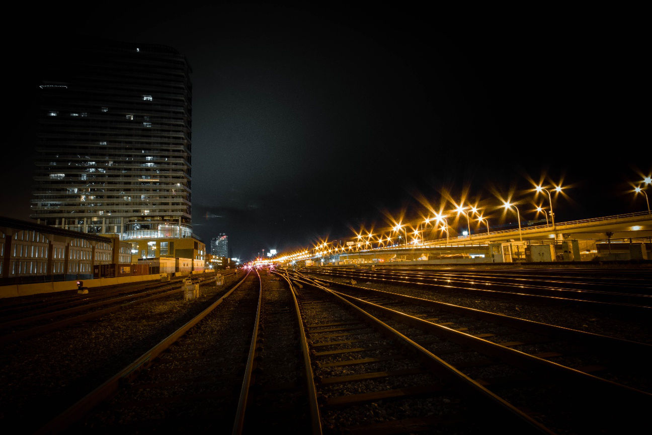 An image of a train station in Toronto viewed from the tracks at night