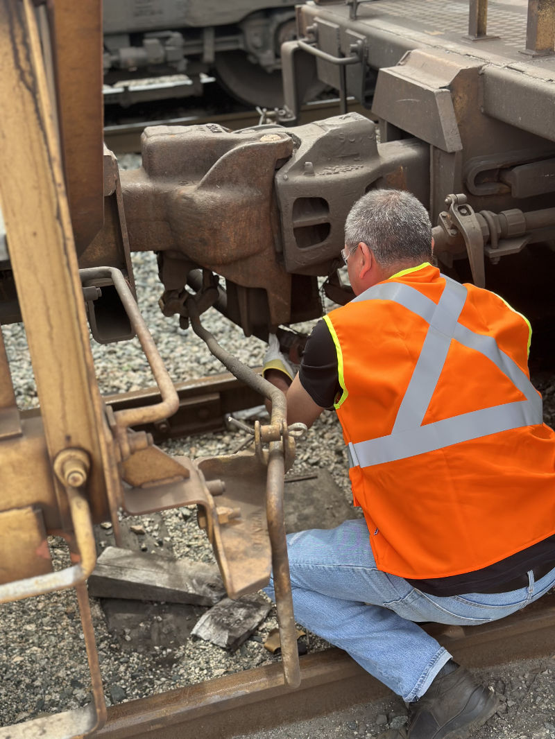 An image of a TTR worker working on a train car