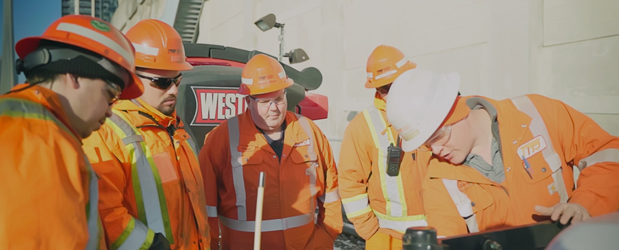 Image of a group of TTR workers watching another worker explain something