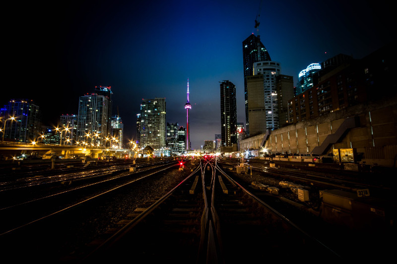 An image of the night skyline of Toronto from the train tracks looking at the CN Tower