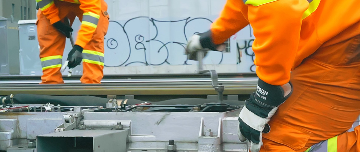 An image of two TTR workers from the knees down working on the tracks